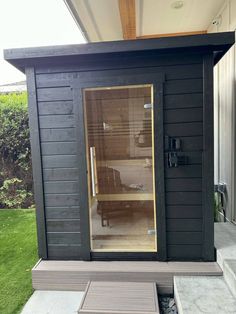 an outdoor sauna is shown with the door open to show it's interior