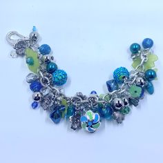 Beautiful Handmade Spring Blue And Green Floral Charm Bracelet Is Chock Full Of Beads And Flower Charms. 10 Inches In Length. Bohemian Blue Charm Bracelet With Colorful Beads, Handmade Blue Bohemian Charm Bracelet, Handmade Blue Dangle Charm Bracelet, Bohemian Blue Charm Bracelet For Gifts, Bohemian Blue Charm Bracelet As A Gift, Bohemian Blue Charm Bracelet As Gift, Bohemian Blue Charm Bracelet Gift, Handmade Blue Charm Bracelet With Round Beads, Handmade Blue Charm Bracelet For Beach