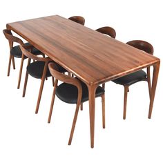 a wooden table with six black chairs and one brown table in the middle, on a white background