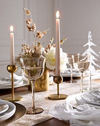 a table set for christmas with candles and plates