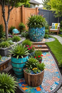 a garden with lots of plants and flowers on the ground in front of a wooden fence