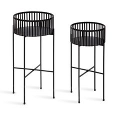 two black metal side tables with round tops on each side, one in the shape of a basket