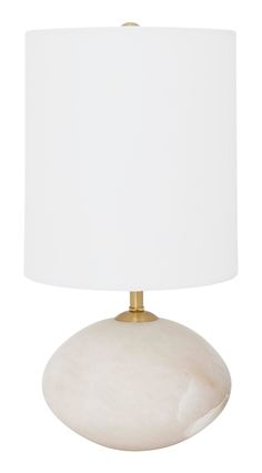 a white lamp with a gold base and a white shade on the top of it