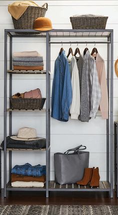 an organized closet with clothes hanging on the rack and shoes in baskets next to it