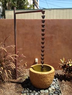 a water fountain in the middle of a rock garden with rocks and gravel around it