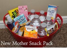 a red bucket filled with lots of different types of snacks and drinks on top of carpet