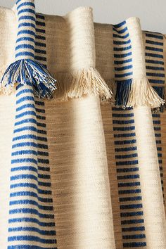 blue and white striped curtains with tassels on them