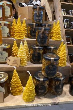 many jars of honey are stacked on top of each other with pine trees in them