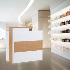 a counter in a store with lots of bottles on the wall and shelves behind it