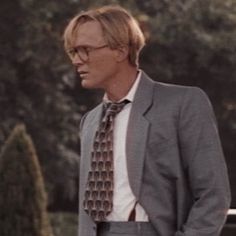 a man in a suit and tie standing outside