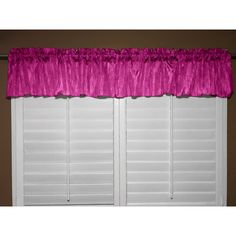 the window valil is pink and has ruffled trim on it, along with white shutters