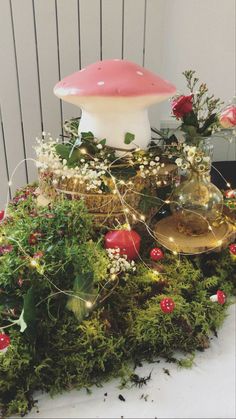 a mushroom lamp sitting on top of a moss covered table