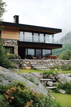 a house that is surrounded by rocks and grass