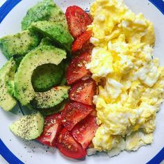 a plate with eggs, tomatoes, avocado and strawberries on it is shown