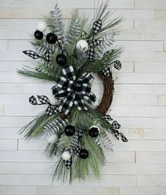 a wreath with black and white ornaments hanging on a wall