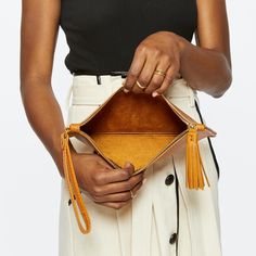 The Finley Clutch is the perfect lightweight bag, complete with hands free leash and secure zipper closure. Whether you’re going out to dinner, visiting the theater, or running about town, the Finley is just large enough to hold your essentials. Porsha is 5'6 and is a size 2. __section__ Designed in Cleveland, Ohio Assembled Ethically by Artisans in the USA and León, Mexico Full-Grain Italian Leather Swiss Made Zipper Solid Brass Hardware A Convenient Leash Tassel Pull Unlined Interior __section Hands Free Leash, Lightweight Bag, Brass Hardware, Italian Leather, Going Out