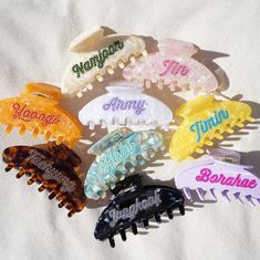 "Claw clips are made of cellulose acetate in beautiful pearlescent colors and embedded with sparkling crystal rhinestones. Claws are larger in size and measure 4\" long, providing enough room to secure even long and fuller hairstyles. There are 9 total claw styles, sold individually and in a collectors set of 9.  Army: white pearlescent claw with lavender crystals  Borahae: lavender claw with fuchsia pink crystals  Namjoon: beige/sand pearlescent swirl claw with olive green crystals  Jin: pink/white pearlescent claw with pink crystals  Yoongi: soft orange pearlescent claw with orange crystals  Hobi: teal/mint/lime pearlescent claw with mint crystals  Jimin: yellow pearlescent claw with baby blue crystals  Taehyung: tortoise brown claw with light brown crystals Jungkook: black/white pearles Crystal Claw Clip, Claw Clip Design, Rhinestone Claw Clip, Custom Claw Clips, Diy Claw Clip, Jimin Yellow, Jin Pink, Lavender Crystals, Jungkook Black