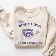 Relax We're All Crazy It's Not A Competition Sweatshirt, Funny Sweatshirt, Vintage Retro Graphic Shirt, Mental Health Shirt, Raccoon Shirt 🧵 HOW TO ORDER   - Pick your size and color from the drop down menus  - Review the sizing and color options in the listing photos  - Add the item to your cart and complete the checkout process  - We'll start working on your order right away! 🧵SIZING  - Please review the listing photos to see the size charts  - These photos will also show you how to order a Raccoon Gift, Sweat Vintage, Raccoon Shirt, Funny Raccoon, Raccoon Funny, Sweatshirt Vintage, Funny Sweatshirts, Graphic Shirt, Looks Style