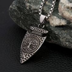 A fusion of Norse symbolism and Viking craftsmanship, designed to evoke the power and mystique of the ancient world. This exquisite necklace is more than just an accessory; it's a symbol of strength, wisdom, and the eternal connection between the realms of existence. At the heart of this captivating piece lies the Yggdrasil, the legendary World Tree, beautifully etched onto a spearhead pendant. The spearhead, a powerful symbol of protection and valor, pays homage to the mighty warriors of old, w Spiritual Stainless Steel Pendant Jewelry, Symbolic Stainless Steel Medallion Jewelry, Spiritual Stainless Steel Jewelry With Oxidized Finish, Stainless Steel Large Pendant Necklaces, Bohemian Stainless Steel Nickel Free Necklaces, Symbolic Adjustable Etched Necklaces, Spiritual Oxidized Pendant Necklace, Adjustable Symbolic Etched Necklace, Symbolic Adjustable Necklace With Oxidized Finish