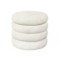 three white round cushions stacked on top of each other in front of a white background