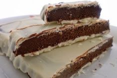 two pieces of cake sitting on top of a white plate with frosting and icing