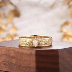 a close up of a gold ring on a wooden surface