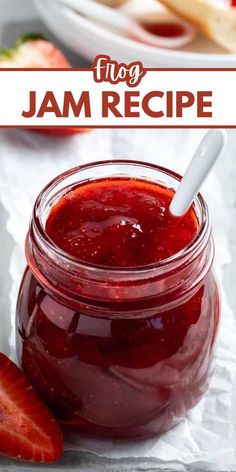 a jar filled with jam next to sliced strawberries