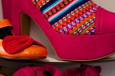 a pair of pink shoes with colorful fabric on them