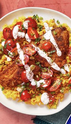 a white plate topped with chicken, rice and tomatoes