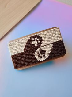 a brown and white knitted hair clip with an angry bird on it