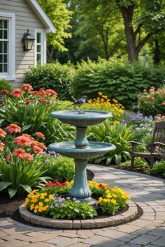 a bird bath in the middle of a garden with colorful flowers and plants around it