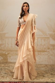 Beige pre-draped saree with ruffle border. Paired with crystal, pearl, zari thread embroidered padded blouse. - Aza Fashions Western Sari, Roka Outfits, Simple Sari, Pre Draped Saree, Saree Gowns, Sari Lehenga, Goa Wedding, Dhoti Saree, Cotton Sarees Handloom