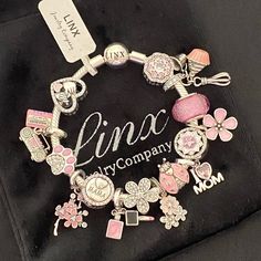 a close up of a charm bracelet on a black cloth with the name lino