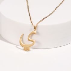 This stunning necklace features a beautifully crafted pendant with a personalized Arabic letter. The elegant design of the letter captures its unique and intricate beauty, making it a focal point of sophistication and charm. The pendant hangs from a delicate chain, perfect for adding a touch of elegance to any outfit. Ideal for everyday wear or special occasions, this necklace makes a meaningful and stylish statement. It also serves as a thoughtful and personalized gift for loved ones, celebrati Symbolic Initial Pendant Charm Necklace As Gift, Elegant Initial Pendant Name Necklace As Gift For Mom, Personalized Gift Charm Necklace With Initial Pendant, Personalized Elegant Initial Necklace For Mom, Elegant Name Pendant Chain Necklace, Symbolic Initial Pendant Jewelry For Gift, Symbolic Pendant Charm Necklaces As Gift, Elegant Initial Pendant Name Necklace For Mom, Symbolic Pendant Charm Necklace As Gift