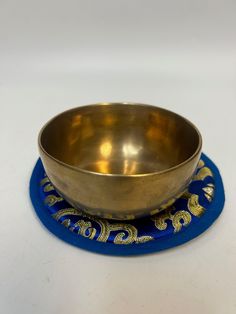 a metal bowl sitting on top of a blue coaster