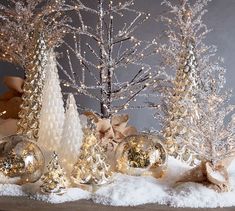 christmas decorations are displayed in front of snow covered trees and ornaments with bows on them