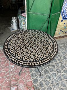 a table sitting on top of a tiled floor next to a green door