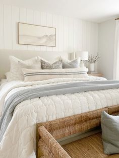 a bed with white sheets and pillows in a bedroom