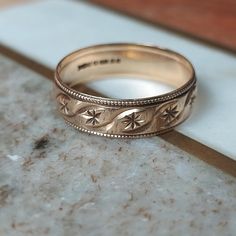 two gold wedding bands sitting on top of a marble counter