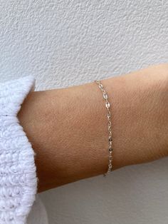 This super sparkly bracelet looks great stacked with other dainty bracelets! D E T A I L S  *925 sterling silver sequin chain measuring 1.8mm wide *A tiny sterling silver cross hangs from the end. *Hallmarked spring ring clasp.  S I Z I N G *  H E L P Choose the length from the drop down menu. Use the length guide as a reference. C A R E * T I P This is a dainty bracelet so please treat it with care. To maintain it in great condition avoid contact with water, perfume and harsh chemicals.Also remove when exercising, sleeping and doing housework in case it snags. Sterling silver can tarnish over time especially in humid conditions so always store in a dry place and if necessary clean with a jewellery cloth. P A C K A G I N G All our products are gift ready. T E R M S* O F* S A L E S & F A Q Silver Sterling Paperclip Bracelet With Adjustable Chain, Sterling Silver Bracelet With Delicate Chain For Everyday, Everyday Sterling Silver Bracelet With Delicate Chain, Delicate Chain Sterling Silver Bracelet For Everyday, Simple Sterling Silver Bracelets In Silver, Simple Sterling Silver Bracelets, Delicate Sterling Silver Adjustable Chain Bracelet, Silver Paperclip Bracelet With Delicate Chain, Silver Delicate Chain Paperclip Bracelet Gift