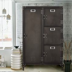 a room with a large metal cabinet next to a window and a rug on the floor