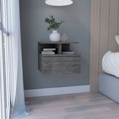 a bedroom with a bed, nightstand and vase on the side table in front of it