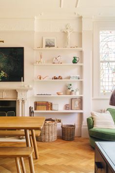 a living room filled with furniture and a fire place in front of a tv mounted on a wall