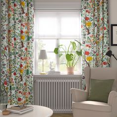 a living room filled with furniture next to a window covered in curtains and drapes