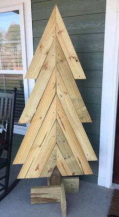 a wooden christmas tree sitting on top of a porch