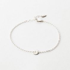 A tiny disk is the perfect place to hold your sweetest little sentiment. Minimalist Sterling Silver Name Bracelet For Personalized Gift, Minimalist Sterling Silver Name Bracelet As Personalized Gift, Dainty Engraved Bracelets For Everyday Wear, Dainty Engraved Bracelets For Everyday, Dainty Engraved Bracelet For Everyday Wear, Dainty Everyday Engraved Bracelets, Dainty Personalized White Gold Bracelets, Personalized Dainty Sterling Silver Chain Bracelet, Adjustable Everyday Jewelry With Initials