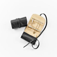 a small black and tan purse with two handles on it's side next to a pair of scissors