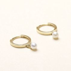 "Elevate your elegance with our Pearl Drop Huggies, meticulously handcrafted in our NYC studio. Crafted with precision from 10K solid gold, these 8mm diameter huggies seamlessly blend sophistication and freshwater pearl charm. - Materials: 10K solid yellow gold and freshwater pearls - Measurement: approximately 0.3\" / 8mm in diameter - The product is made to last forever. Solid gold will not oxidize or discolor - Contact us sales@shapesstudionyc.com for custom orders" Huggie Earrings With Lever Back For Wedding, Elegant Adjustable White Gold Huggie Earrings, Elegant Adjustable Yellow Gold Huggie Earrings, Elegant Adjustable Huggie Earrings For Anniversary, 14k Gold Huggie Hoop Earrings With Pearl Drop, Elegant Yellow Gold Adjustable Huggie Earrings, Hypoallergenic Yellow Gold Huggie Pearl Earrings, Handmade Yellow Gold Huggie Earrings, Elegant Handmade Yellow Gold Huggie Earrings