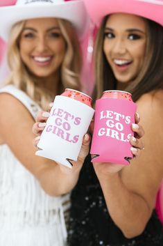 two women wearing hats and holding pink can coolers with let's go girls written on them