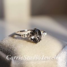 a close up of a ring on top of a white cloth with diamonds in it